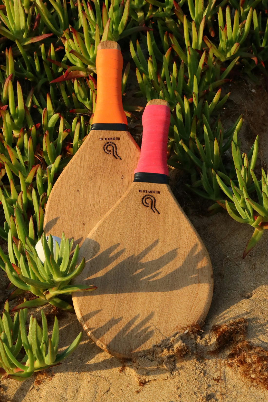 a couple of paddles sitting on top of a sandy beach