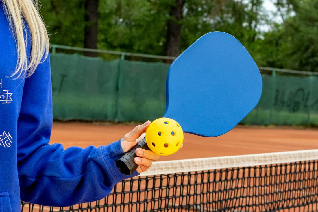 a person holding a tennis racket and a ball