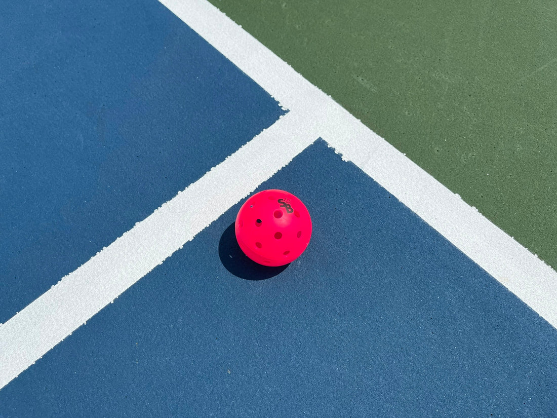 a red ball on a blue tennis court