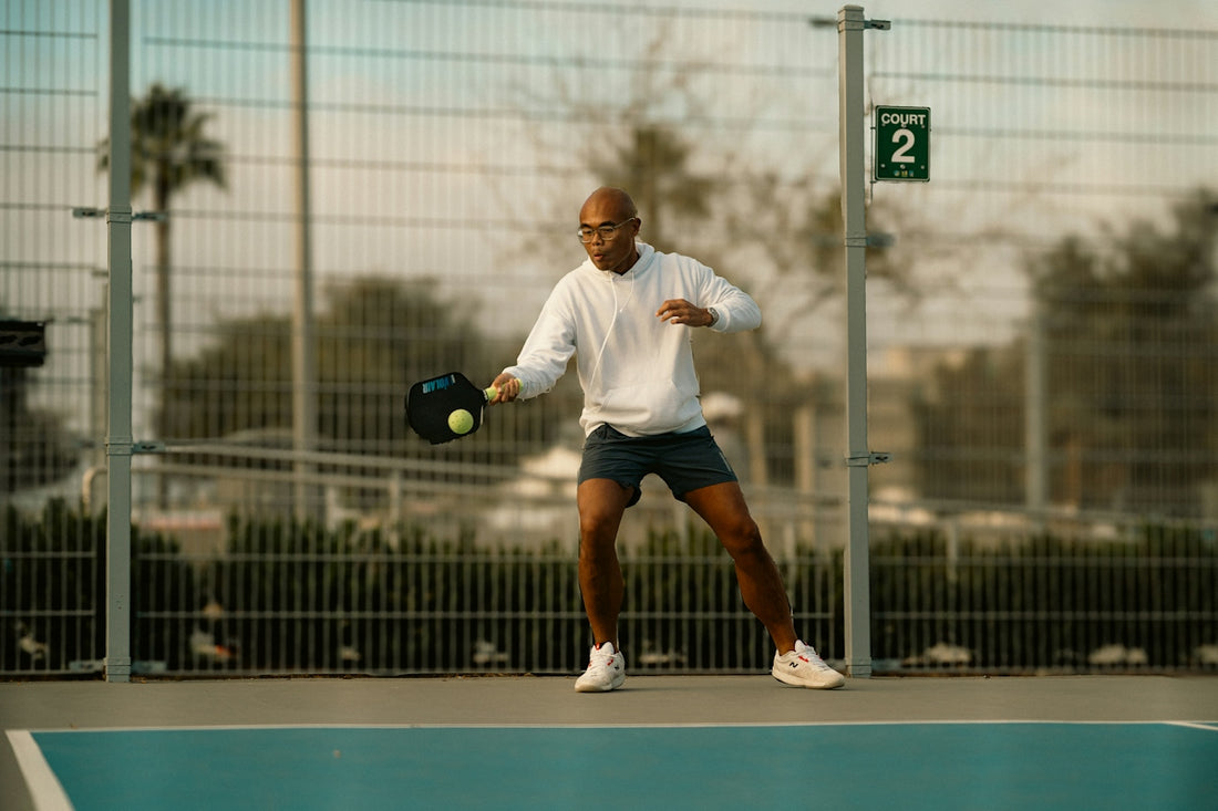 A man holding a tennis racquet on top of a tennis court