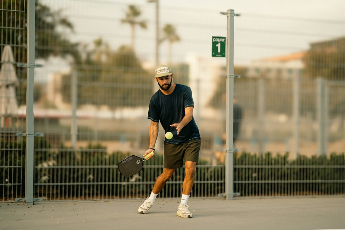 A man holding a tennis racquet on top of a tennis court