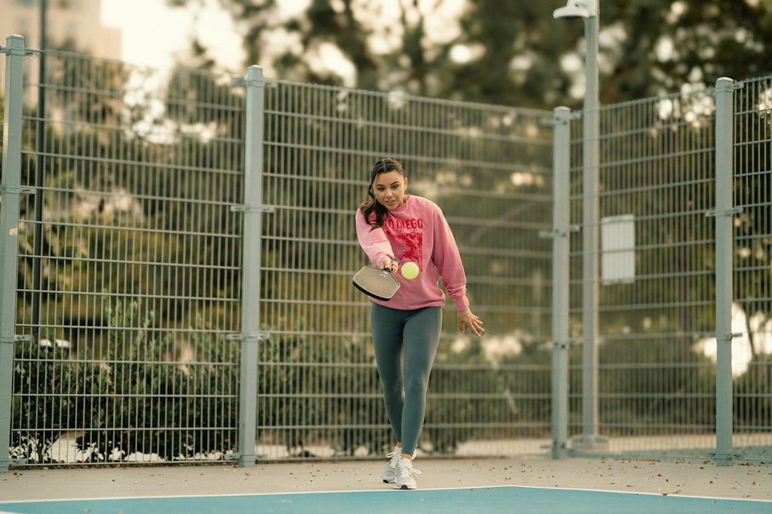 A woman holding a tennis racquet on top of a tennis court