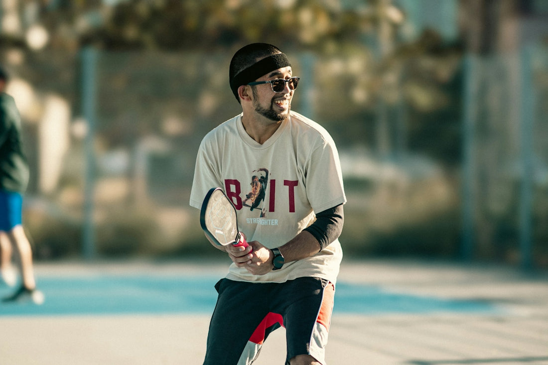 A man holding a tennis racquet on top of a tennis court