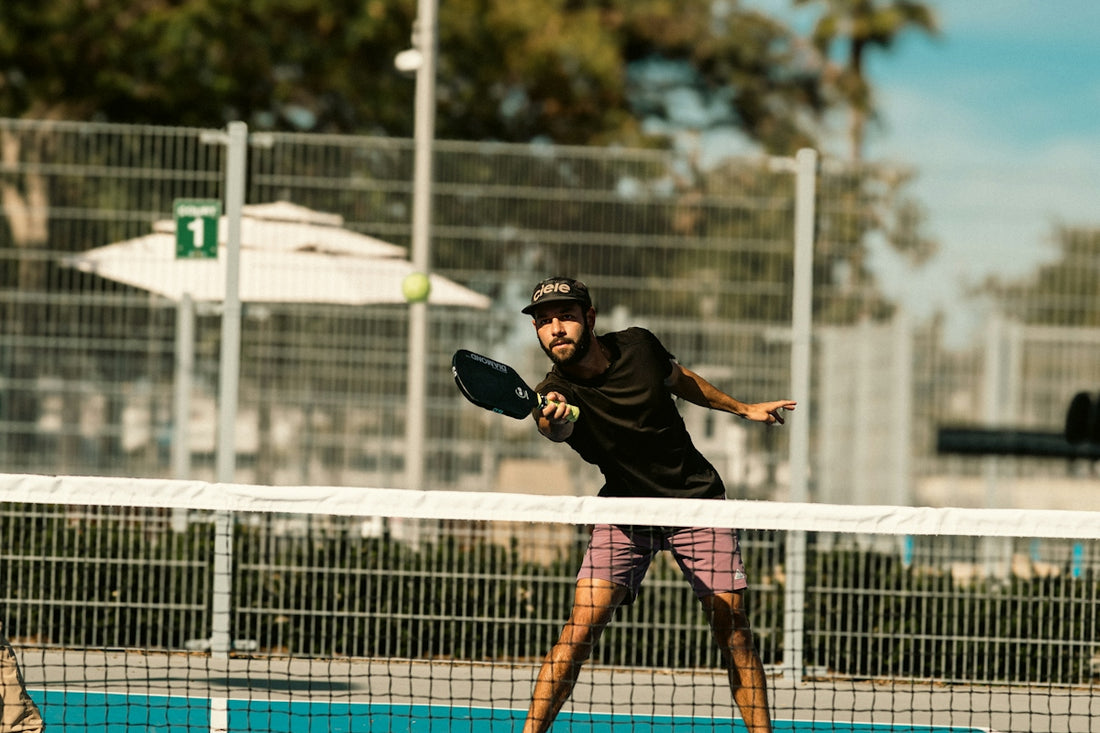 A man holding a tennis racquet on top of a tennis court