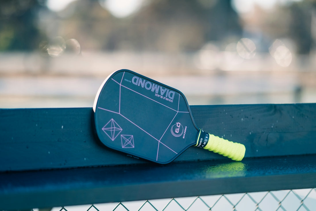 A close up of a tennis racket on a bench