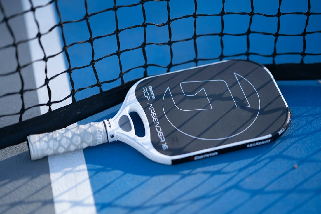 A tennis racket laying on the ground next to a net